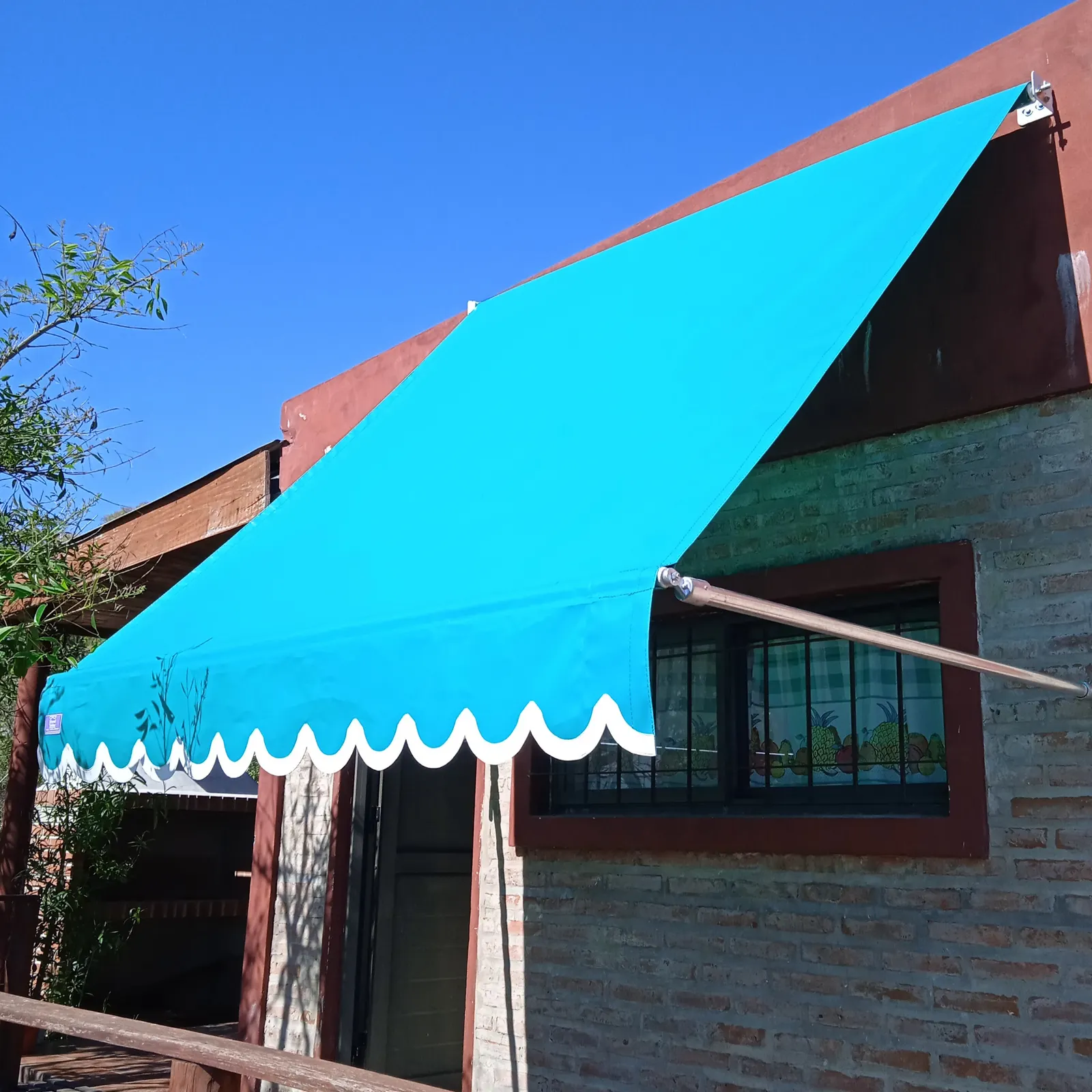 Toldo sin fin con brazos rectos extendido sobre una ventana